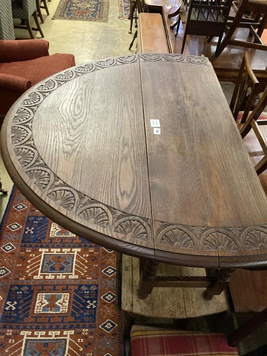 A low oak oval topped gateleg table, width 105cm extended 130cm height 51cm